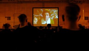 A cinema audience watching a film premiere on a big screen