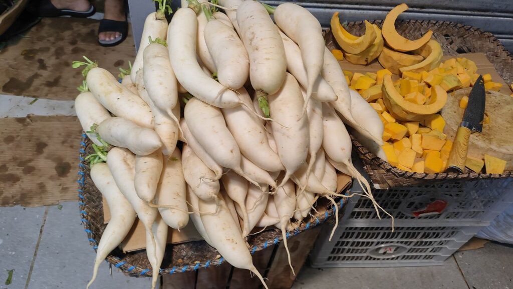A market stall piled with fresh vegetables