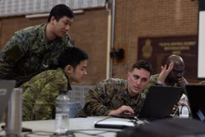 Soldiers planning a defence against cyber attacks at computer workstations