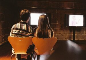 A couple watching television together in a dark room
